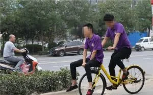 西安街头现100斤小伙坐在共享单车车筐